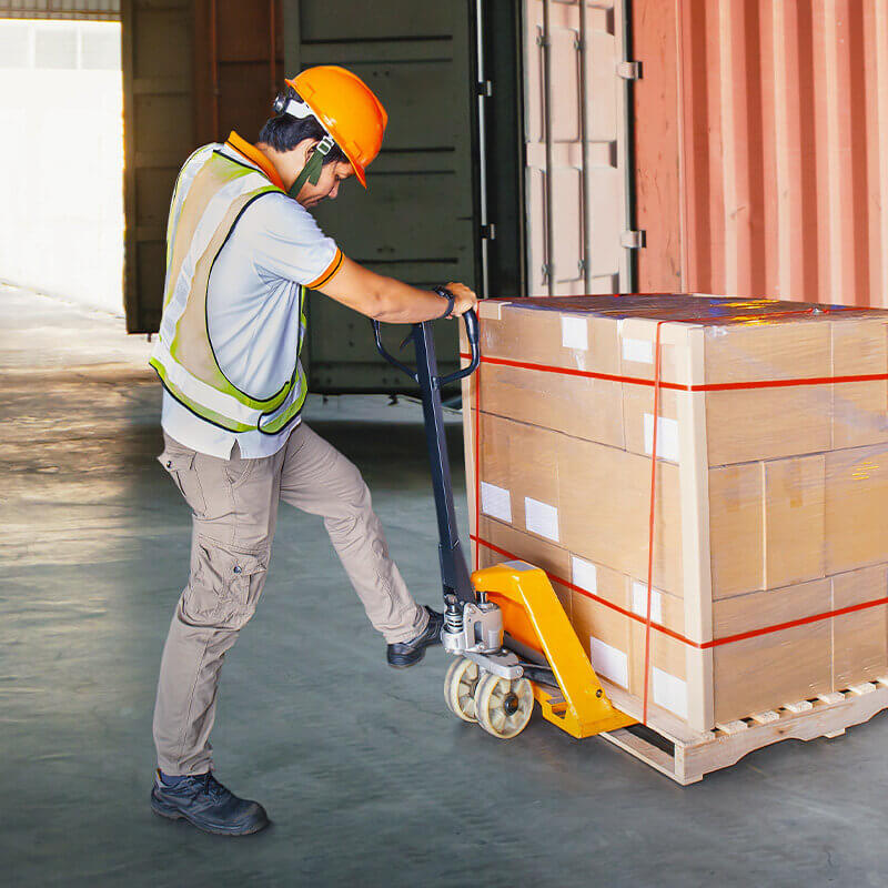 Man unloading a pallet using a pallet jack.