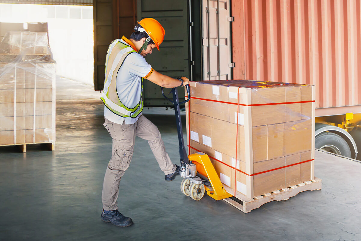 Man unloading a pallet using a pallet jack.