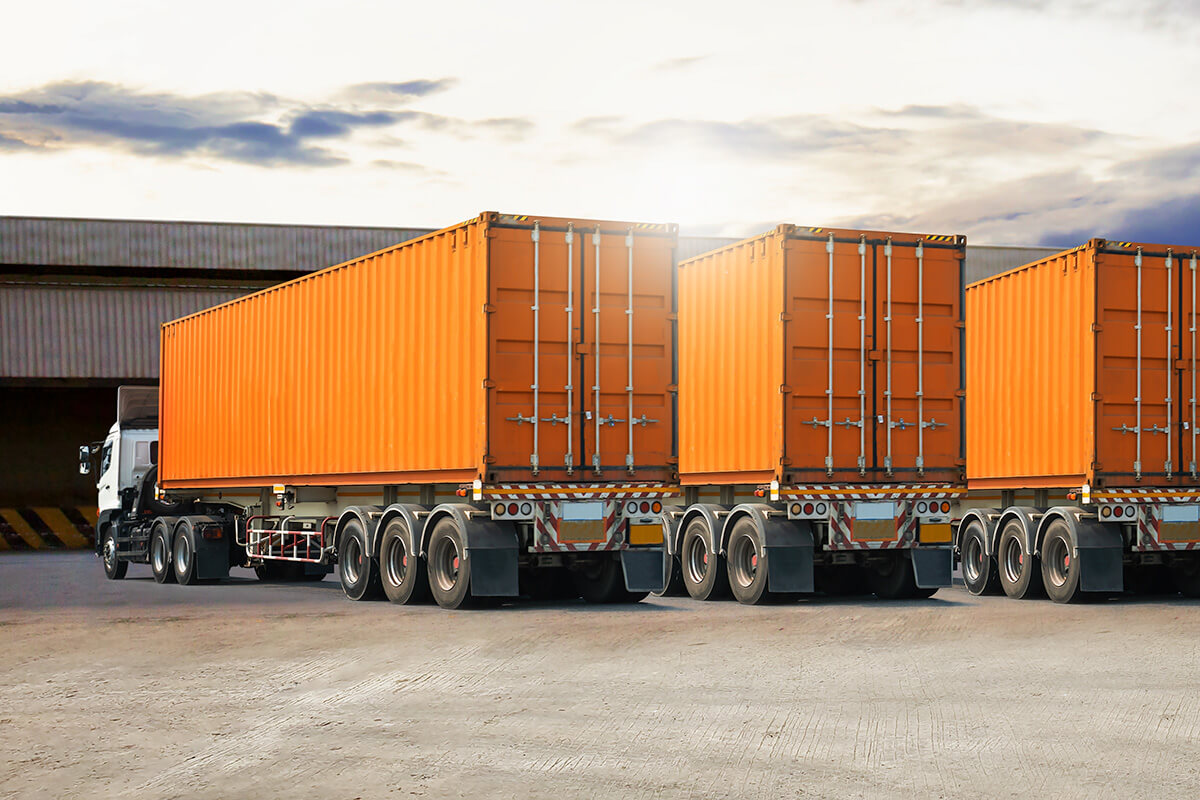 trucks with orange colored containers are positioned at the dock